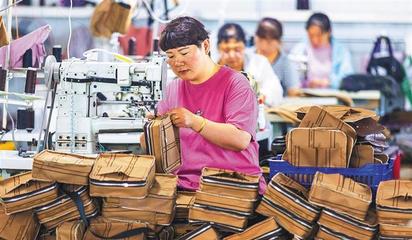 阜平縣顧家臺村九歌皮具有限公司,村民在加工箱包。當?shù)厣a(chǎn)的箱包通過線上線下俏銷全國各地。