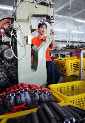 圖文:工人正在制作箱包的提手